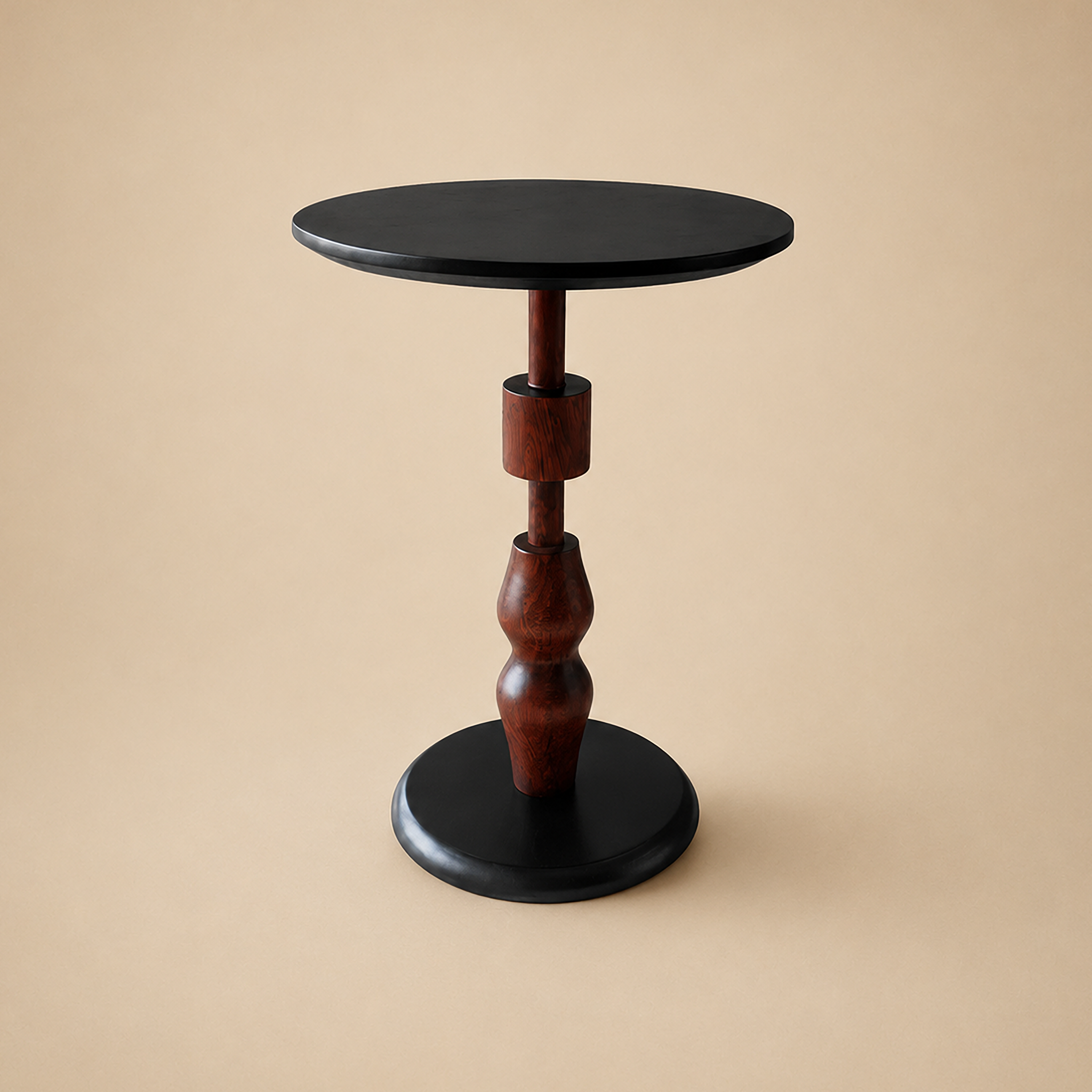 Sthir end table with a slim turned-wood spindle on a round black base and matching black top, on a neutral backdrop